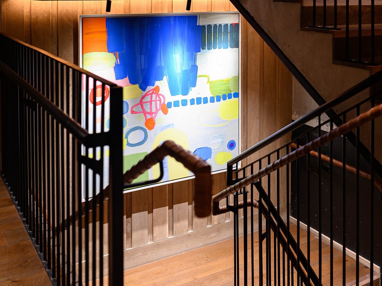 An art piece hanging on a wall going up a staircase