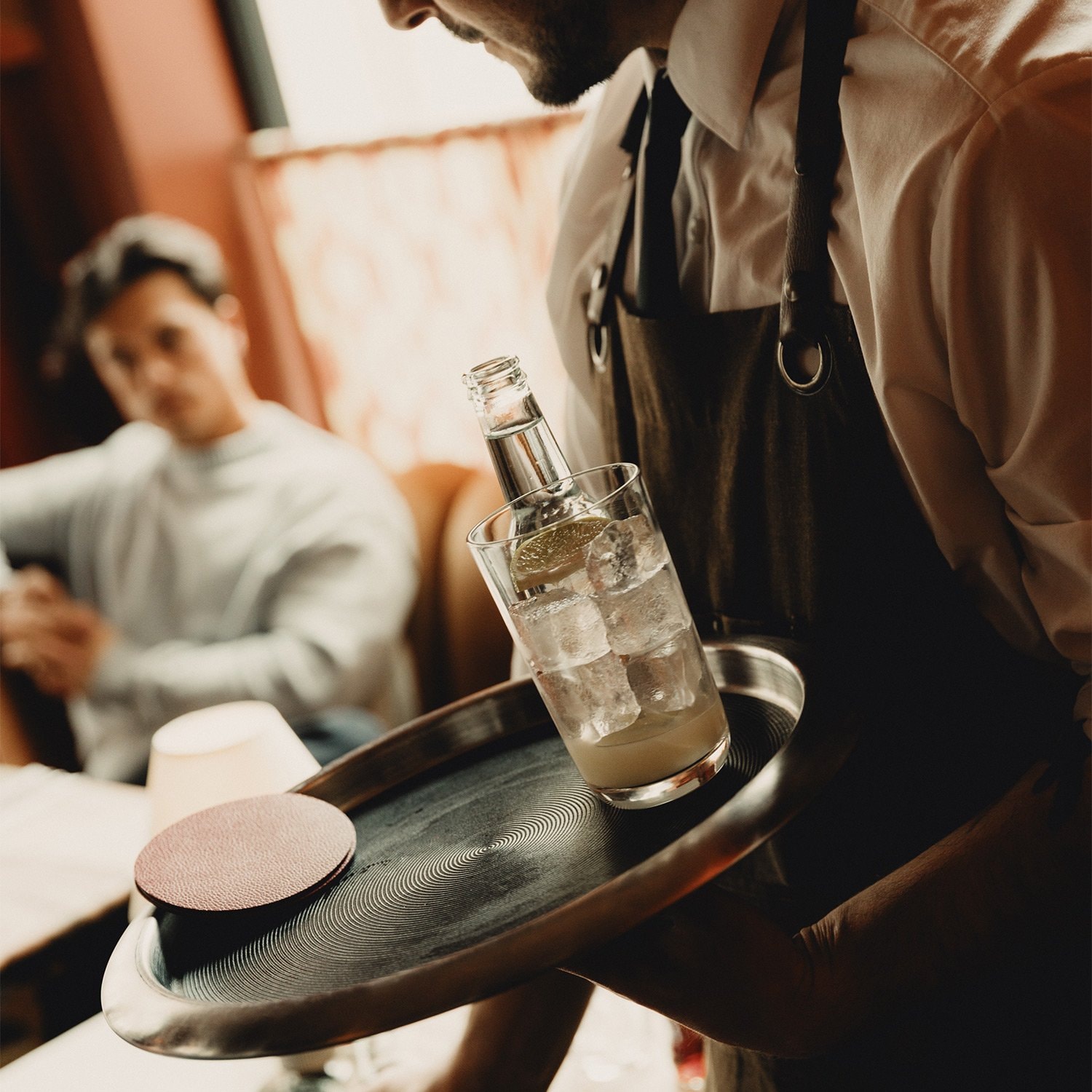 A bus boy picking up dirty dishes